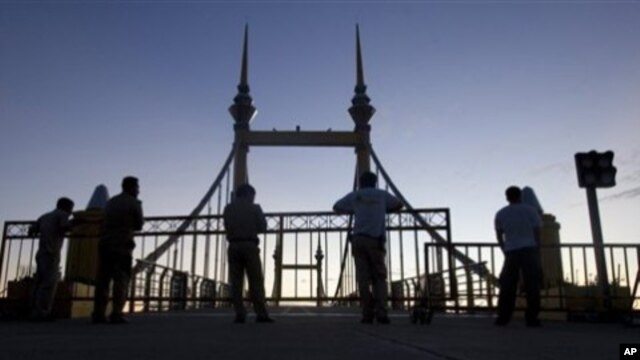 Cambodian police officers stand guard on a bridge where hundreds of people stampeded during a water festival in Phnom Penh, Cambodia, 28 Nov 2010