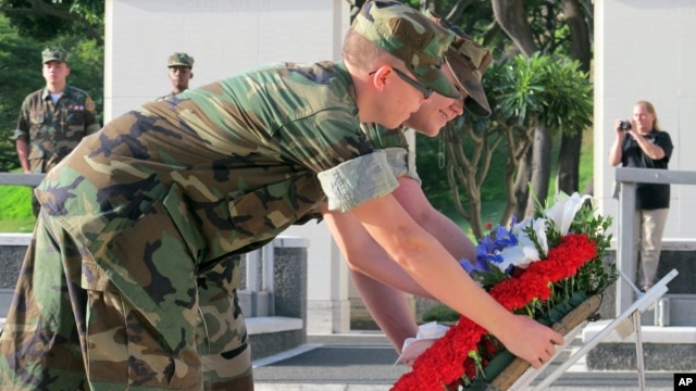 Marines Andrew Cardwell of Cincinnati, Ohio, left, and Sarah Robbins of Denver, Colo., lay a wreath at the National Memorial Cemetery of the Pacific in Honolulu, Dec. 6, 2012.