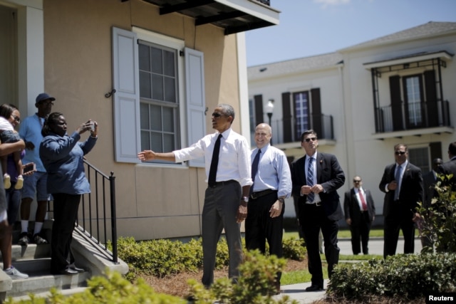 U.S. President Barack Obama, with New Orleans Mayor Mitch Landrieu at his back, chats with city residents in an area reconstructed after Hurricane Katrina, Aug. 27, 2015.