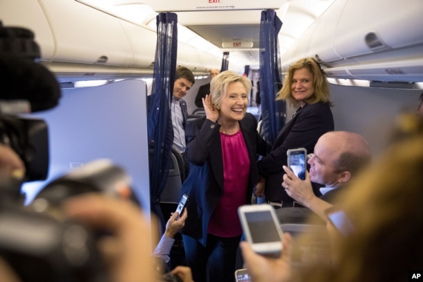 Democratic presidential candidate Hillary Clinton, accompanied by traveling press secretary Nick Merrill, left, and director of communications Jennifer Palmieri, right, listens to a question from a member of the media as her campaign plane prepares to take off at Westchester County Airport in Westchester, N.Y., Tuesday, Sept. 6, 2016, to head to Tampa for a rally in Tampa.