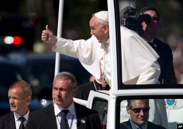 Pope Francis give the thumbs-up from the popemobile during a parade around the Ellipse near the White House in Washington, Sept. 23, 2015.