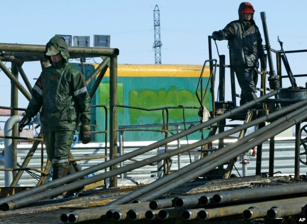 FILE - Oil workers prepare to pump water into the Priobskoye oil field in Western Siberia, which once belonged to the Yukos oil company.