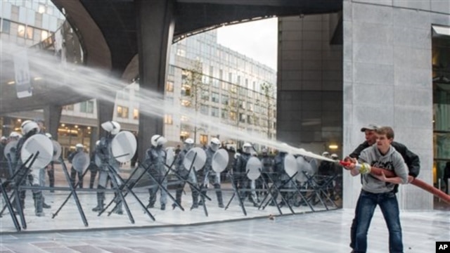 Evropski mlekari prskaju policiju mlekom iz šmrka za vreme demonstracija ispred Evropskog parlamenta u Briselu.