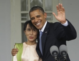 US President Barack Obama (R) waves as he embraces Burmese democracy activist Aung San Suu Kyi after addressing members of the media at Suu Kyi's residence in Rangoon, Burma, November 19, 2012.