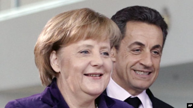 French President Nicolas Sarkozy (R) and German Chancellor Angela Merkel arrive for a news conference following their talks at the Chancellery in Berlin January 9, 2012