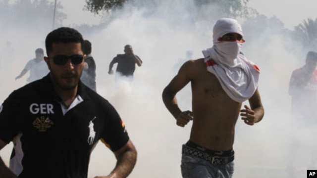 Anti-government protesters run away from tear-gas fired by riot police during a demonstration in Manama (file photo).