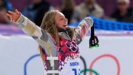 Jamie Anderson of the United States celebrates on the way to the flower ceremony after winning the women's snowboard slopestyle final at the 2014 Winter Olympics, Sunday, Feb. 9, 2014, in Krasnaya Polyana, Russia. 
