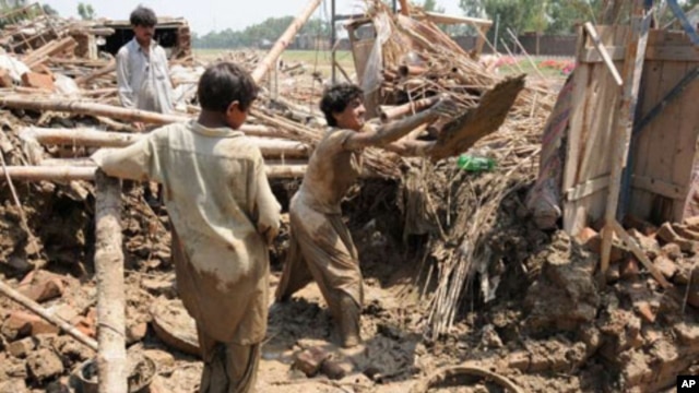 Men digging up the remains of their home in the Azakhel refugee camp, near Peshawar, following the floods that have left much of Pakistan in misery, Aug 2010