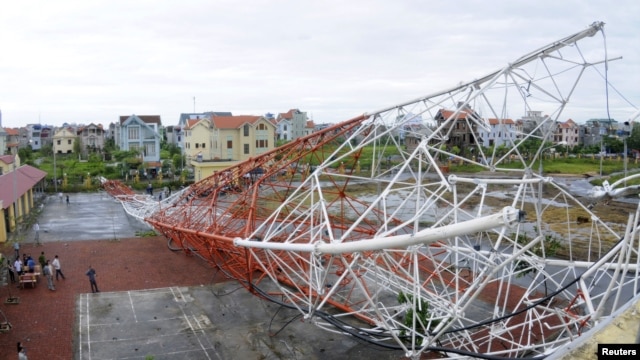 People look at the Nam Dinh television tower which collapsed due to Typhoon Son-Tinh in Nam Dinh city, 100 km (62 miles) south of Hanoi, October 29, 2012.