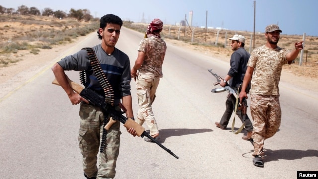 FILE - Libya Dawn fighters search for Islamic State militant positions during a patrol near Sirte.