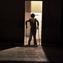 A November 2011 file photo shows a youth suffering from polio walking through a doorway at the Stand Proud compound in Kinshasa, Republic of Congo