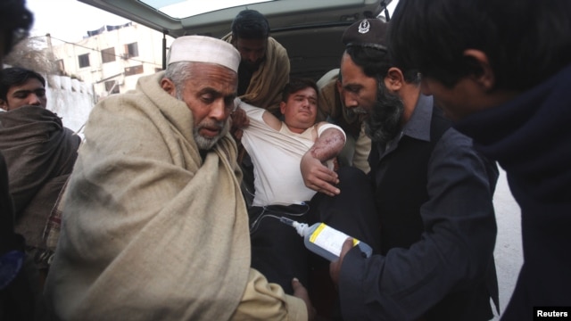 An injured driver (in white) who survived a shooting by unidentified gunmen in Swabi, arrives at the Lady Reading Hospital in Peshawar, January 1, 2013.