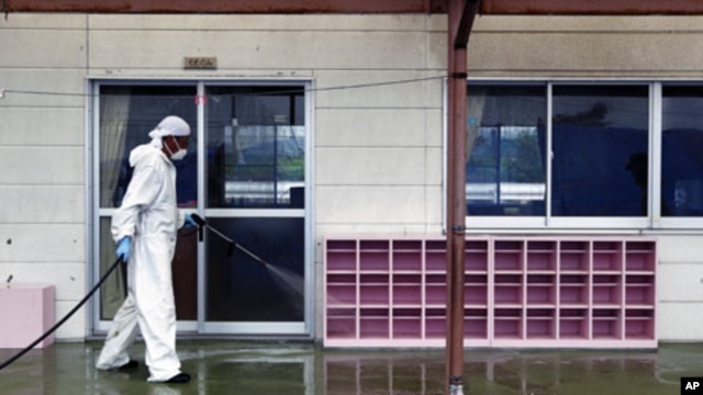 A worker decontaminates radiation from the exterior of Yasawa Kindergarten in Minami-Soma, about 20 kilometers away from the crippled Fukushima Dai-ichi nuclear facility in Fukushima prefecture, northeastern Japan,  August 18, 2011.