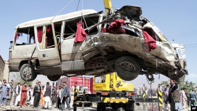 A damaged bus which was hit by a remote control bomb is lifted by a crane on the outskirts of Kabul, Afghanistan, August 7, 2012.