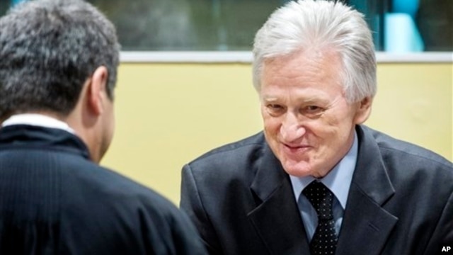 Gen. Momcilo Perisic, former chief of staff of the Yugoslav national army, right, talks to his lawyer prior to appeal judgment The Hague, Feb. 28, 2013.