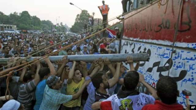 Protesters tear down a concrete wall built in front of the Israeli embassy in Cairo, Egypt, September 9, 2011