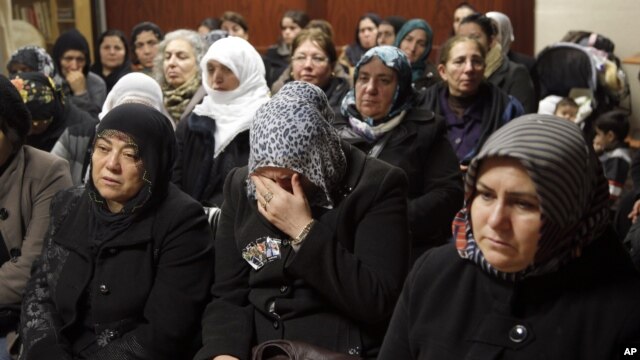 Women react inside the Kurdish cultural center in Paris, January 10, 2013. 