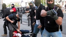 Plain clothes police officers arrest a soccer fan during clashes before the Poland and Russia Group A Euro 2012 soccer match in Warsaw, June 12, 2012.