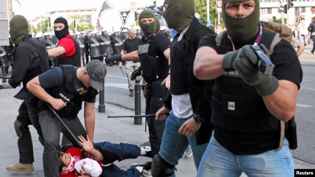 Plain clothes police officers arrest a soccer fan during clashes before the Poland and Russia Group A Euro 2012 soccer match in Warsaw, June 12, 2012.