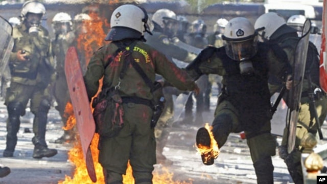 Riot police deal with an exploding petrol bomb during riots by anti-austerity demonstrators in Athens' Syntagma [Constitution] square, October 19, 2011.