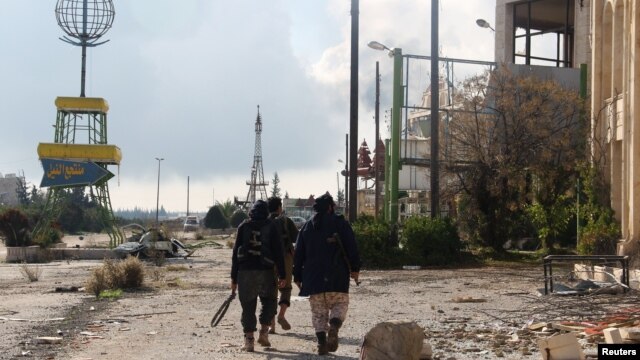 Rebel fighters walk around al-Hamidiyeh base, one of two military posts they took control of from forces loyal to Syria's President Bashar al-Assad in the northwestern province of Idlib, Dec. 15, 2014. 
