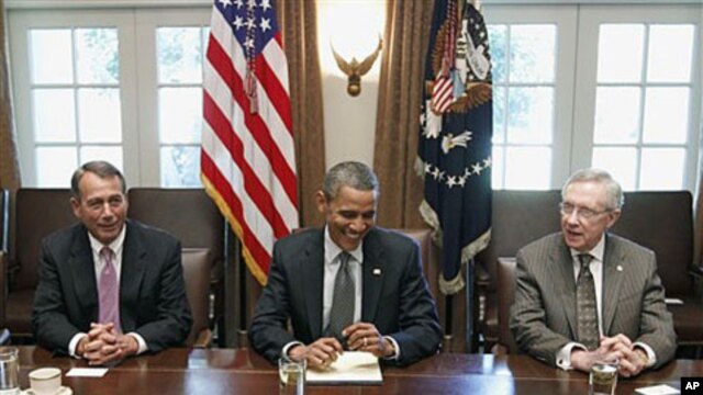 President Barack Obama sits with House Speaker John Boehner of Ohio (L), and Senate Majority Leader Harry Reid, as he met with Republican and Democratic leaders regarding the debt ceiling, at the White House in Washington, DC, July 14, 2011