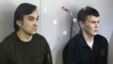 Yevgeny Yerofeyev (L) and Aleksander Aleksandrov, Russian servicemen arrested last May on terrorism charges related to the separatist conflict in eastern Ukraine, looks from a glass-walled cage during a court hearing in Kyiv, Ukraine, April 18, 2016.