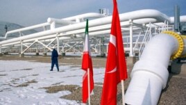 A worker walks past the pumping station on the border between Iran and Turkey during the inauguration ceremony for the Iran-Turkey gas pipeline, January 22, 2002. 