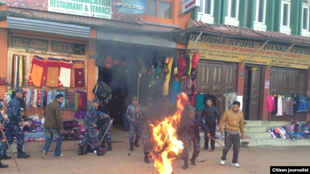 Nepalese police react to a Tibetan exile who set himself on fire in Kathmandu, February 13, 2013.