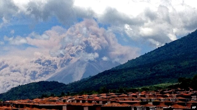 En esta foto tomada con un teléfono celular, el Volcán de Fuego lanza humo y cenizas. La imagen fue captada en el pueblo de Palin, al sur de Ciudad de Guatemala, la capital del país.