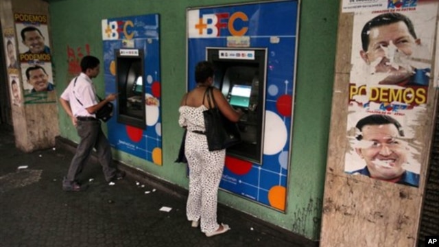 Warga Venezuela menarik uang tunai dari mesin ATM di Caracas, Venezuela (8/2). Pemerintah Venezuela mengumumkan devaluasi (penurunan nilai) mata uang bolivar terhadap dolar menjadi enam koma 30 bolivar untuk satu dolar, yang mulai berlaku hari Rabu pekan mendatang. 