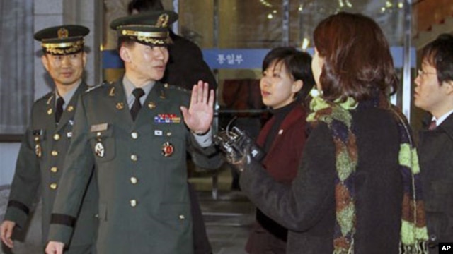 South Korean delegate Army Col. Moon Sang-gyun, second from left, is questioned by reporters as he leaves for military meeting with North Korea in Seoul, South Korea, February 8, 2011.