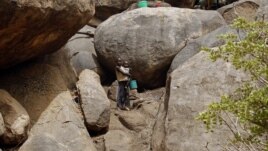 Children stand outside a cave shelter in Tess village in the rebel-held territory of the Nuba Mountains in South Kordofan May 2, 2012. 
