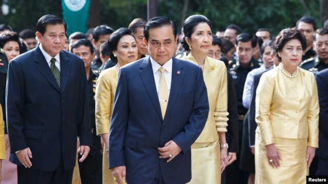 Thailand's Prime Minister Prayuth Chan-ocha (C), his wife Naraporn Chan-ocha (2nd R) and his cabinet pray for the health of Thailand's revered King Bhumibol Adulyadej, at the Siriraj hospital in Bangkok, Oct. 6, 2014.