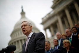 FILE - U.S. Senate Majority Leader Harry Reid, with other Democratic Party Senate members in the background, is seen on the steps of the U.S. Capitol in Washington, D.C.