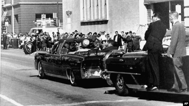 Xe chở nhân viên mật vụ chạy sau chiếc limousine chở Tổng thống Kennedy và phu nhân, trong thành phố Dallas, Texas, ngày 22/11/1963.