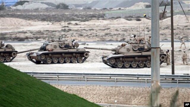Bahraini soldiers in tanks and armored vehicles stand ready, Feb 17 2011, near a main highway west of the capital of Manama