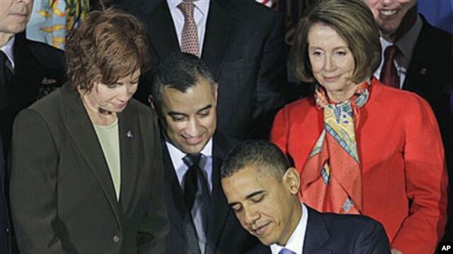 President Barack Obama signs the Don't Ask, Don't Tell Repeal Act of 2010 with, from left, Commander Zoe Dunning, Marine Staff Sgt. Eric Alva, and House Speaker Nancy Pelosi of Calif., at the Interior Department in Washington, Dec 22, 2010