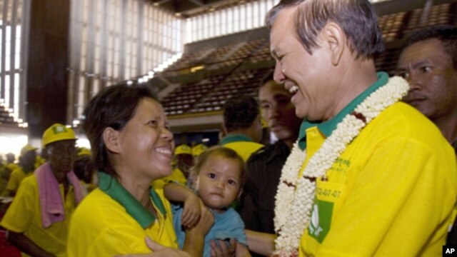 Human Rights Party President Kem Sokha, right, greets a party member as he attends the new party's congress in Phnom Penh. 
