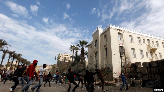 Waandamanaji wanaompinga rais Morsi wakirusha mawe kwa polisi wa kutuliza ghasia mjini Cairo, January 25, 2013. 
