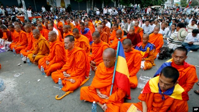 Các nhà sư Campuchia và những người biểu tình ngồi thiền 5 phút trong một cuộc biểu tình tại một con phố bị chặn gần Đại sứ quán Việt Nam ở Phnom Penh, 13/8/2014.