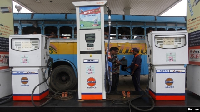 An employee fills diesel in a public bus at a fuel station in Kolkata, August 13, 2012. 