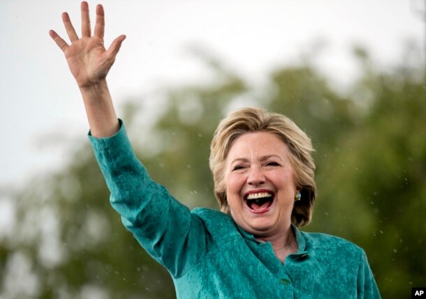 Democratic presidential candidate Hillary Clinton waves as she cuts her speech short because of heavy rain at a rally at C.B. Smith Park in Pembroke Pines, Fla., Nov. 5, 2016.