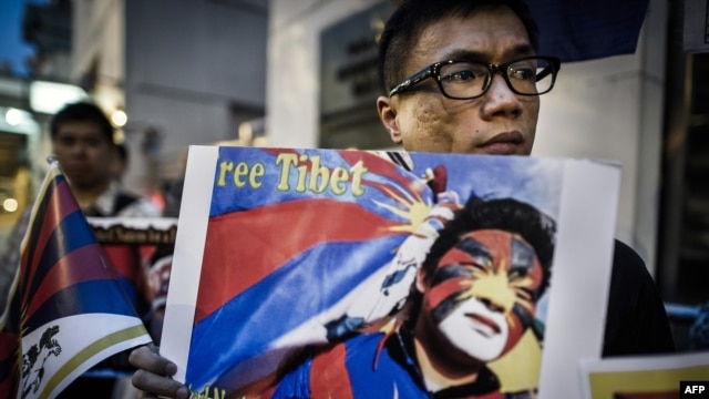 Rights group activists stage a protest to raise awareness on the human rights situation in Tibet and the closure of the territory to foreign visitors, outside the Chinese liaison office in Hong Kong, June 20, 2012. 