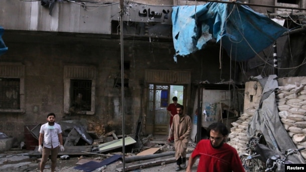 Medics inspect the damage outside a field hospital after an airstrike in the rebel-held al-Maadi neighborhood of Aleppo, Syria, Sept. 28, 2016.