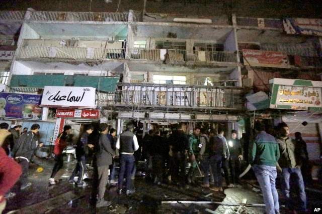 People gather in front of the mall in Baghdad, Iraq, on Jan. 11, 2016. Gunmen stormed into the mall Monday, spraying bullets at shoppers before blowing themselves up.