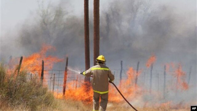 A volunteer firefighter fights a fire which began outside Marfa, Texas, and was carried by winds to nearby Fort Davis, April 9, 2011