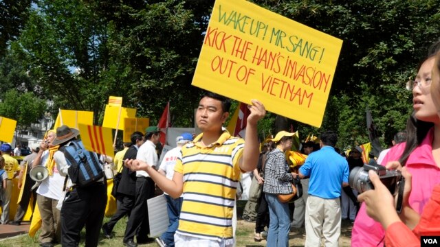 Một thanh niên biểu tình cầm biểu ngữ với hàng chữ kêu gọi Chủ tịch Sang hãy hành động để đánh đuổi Trung Quốc xâm lược ra khỏi Việt Nam.