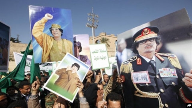 Supporters of Libyan leader Moammar Gadhafi hold his pictures as they take part in a pro-government rally in Tripoli, February 17, 2011