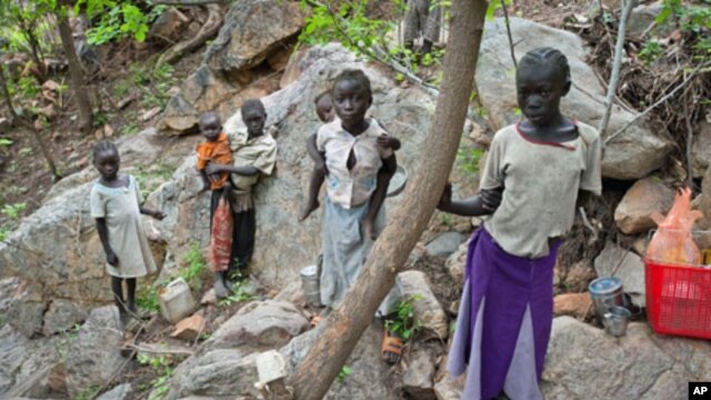 Sudanese children displaced from their homes in the rebel stronghold of Kauda take shelter in the hills surrounding the town in the Nuba mountains as they flee with their families from government bombardment, June 30, 2011